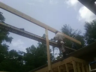 Carpenter setting a ridge beam over a new addition frame — Ice Dam Removal by Roofing Brothers in Pelham